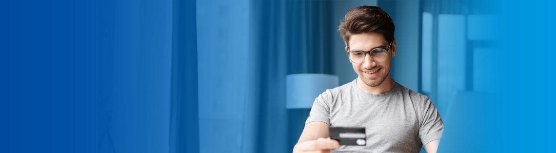 Joven mirando una tarjeta de débito